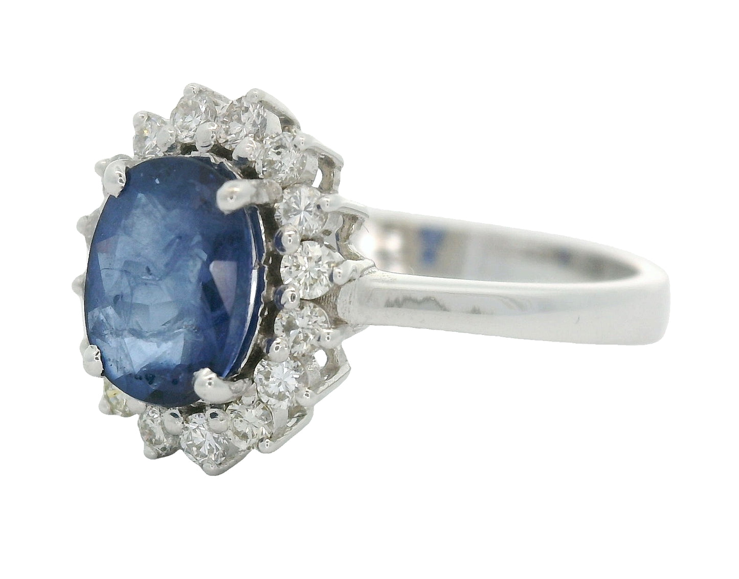18 karaat witgouden rozetring van 3.3 gram. en 2.5 mm breed. Bezet met 1 ovaal geslepen saffier van 1.10 crt. en 16 briljant geslepen diamanten met een totaalgewicht van 0.16 crt. Kleur:G Kwaliteit: SI2 Zetting:11 x 9 mm Model: R 10543