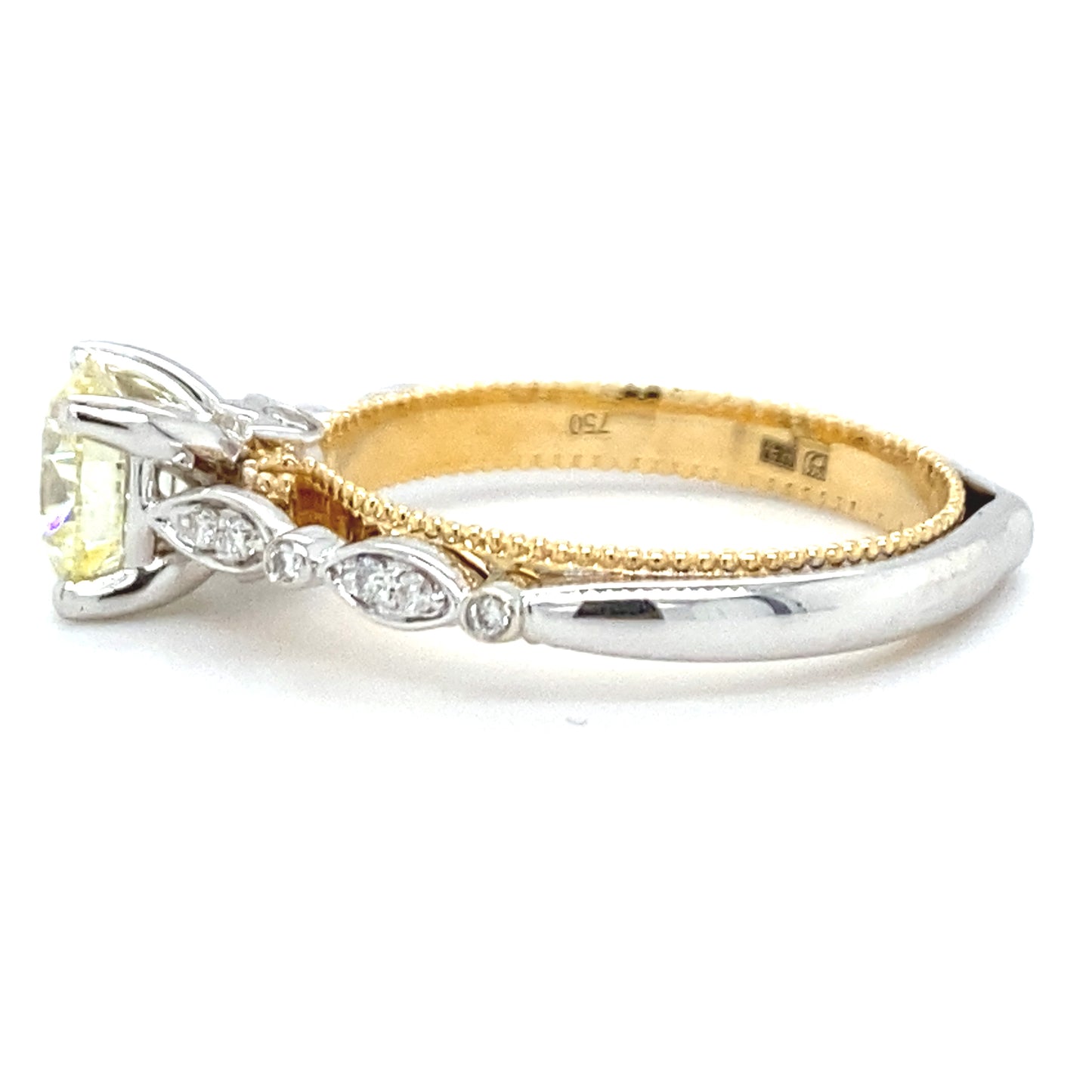 18 karaats wit met geel gouden fantasie ring van 4.15 gram en 3mm breed. Bezet met 1 briljant geslepen diamant van 1.12 crt kleur lichtgeel kwaliteit vs2 en 14 briljant geslepen diamanten met een totaalgewicht van 0.09 crt kleur G kwaliteit vs2 Model R8720