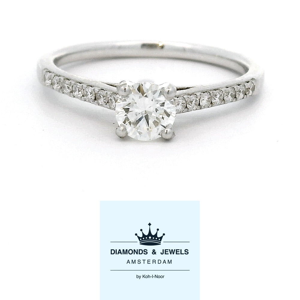 18 karaat witgouden solitair pavé ring van 2 mm breed en 2.32 gram. Bezet met 1 briljant geslepen diamant van 0.40 crt Kleur: G Kwaliteit: VS2 en 16 briljant geslepen diamanten met een totaalgewicht van 0.15 crt Kleur: G Kwaliteit: VS1 Zetting: Ø 5 mm Model: R 10770