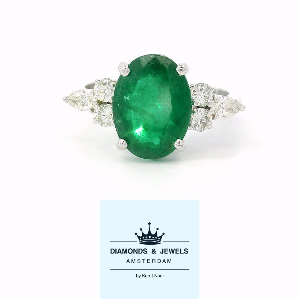 18 karaat wit gouden fantasie trilogie ring van 3.76 gram en 2 tot 3 mm breed. Bezet met 1 ovaal geslepen smaragd van 3.00 crt en 4 briljant geslepen diamanten met een totaalgewicht van 0.20 crt Kleur: G Kwaliteit: SI2 Zetting: 11 x 19 mm. Model: R 10772