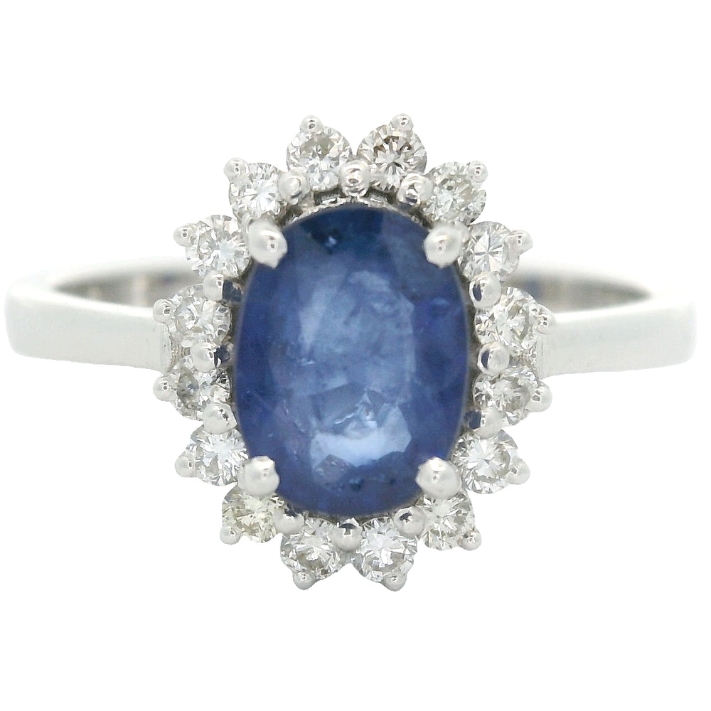 18 karaat witgouden rozetring van 3.3 gram. en 2.5 mm breed. Bezet met 1 ovaal geslepen saffier van 1.10 crt. en 16 briljant geslepen diamanten met een totaalgewicht van 0.16 crt. Kleur:G Kwaliteit: SI2 Zetting:11 x 9 mm Model: R 10543