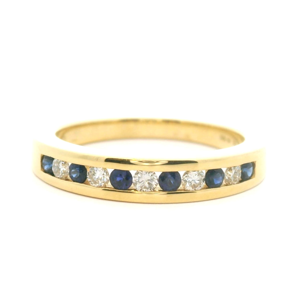 18 karaat geel gouden rijring van 4.27 gram en 2 tot 4 mm breed. Bezet met 6 saffieren met een totaalgewicht van 0.23 crt en 5 briljant geslepen diamanten met een totaalgewicht van 0.19 crt. Kleur: Top Wesselton Kwaliteit: VS1 Model: R 9952