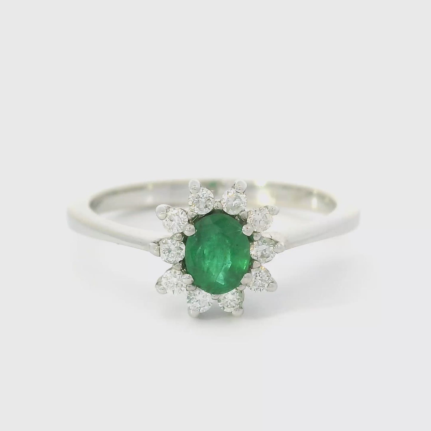 14 karaat wit gouden rozet ring van 2. gram en 1 tot 2 mm breed. Bezet met 1 ovaal geslepen smaragd van 0.33 crt en 10 briljant geslepen diamanten met een totaalgewicht van 0.18 Kleur H Kwaliteit: SI Zetting: 10 x 9 mm Model: R 10167
