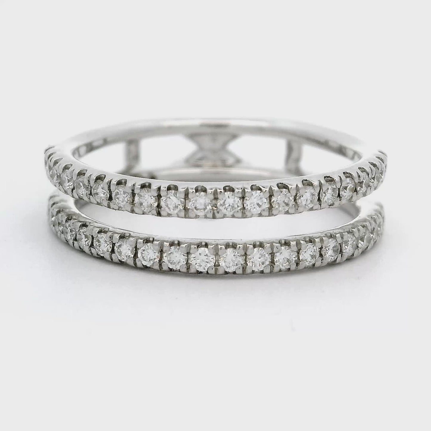 18 karaat witgouden designer rijring. De ring heeft een opening tussen twee rijen aan diamanten. De ring is in totaal bezet met 44 briljant geslepen diamanten van een hoge kleur en kwaliteit. Breedte van de ring is 5.5 mm