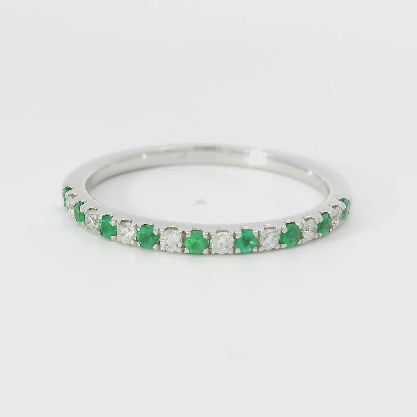 18 karaat wit gouden rijring van 1.7 gram en 2 mm breed. Om en om bezet met 8 briljant geslepen diamanten met een totaalgewicht van 0.11 crt Kleur: F Kwaliteit: VS en 9 smaragden met een totaalgewicht van 0.12 crt. Model: R 10056