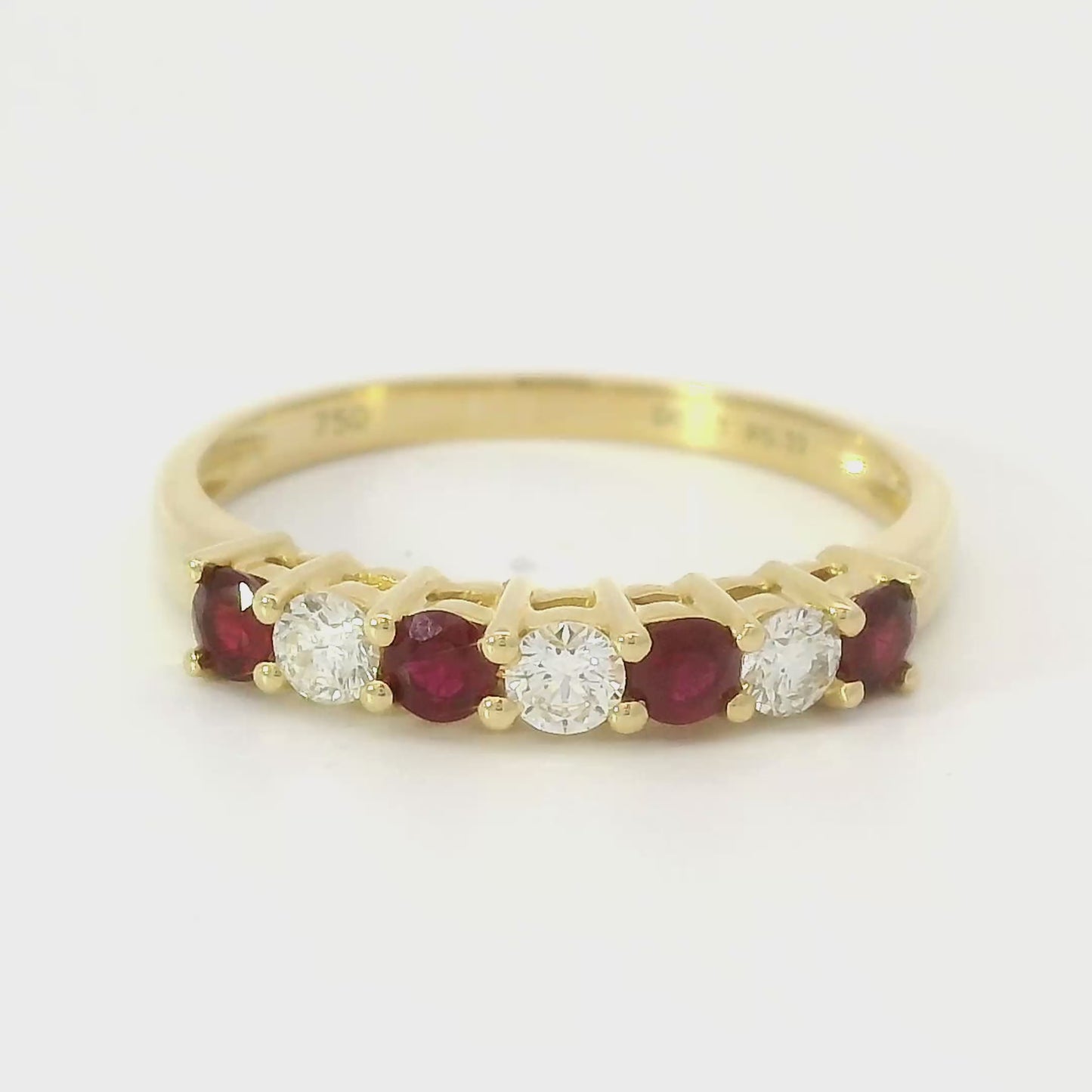 18 karaat geelgouden rijring van 2.05 gram. Bezet met 3 briljant geslepen diamanten met een totaalgewicht van 0.23 crt Kleur: G Kwaliteit: VS2 en 4 robijnen met een totaalgewicht van 0.32 crt. Zetting: 12 x 3 mm Model: R 60669