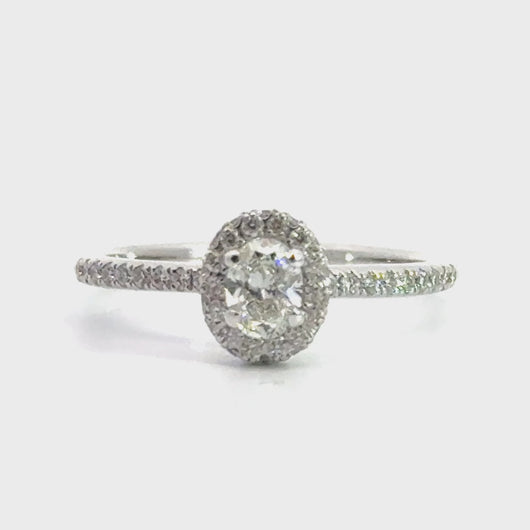 18 karaat witgouden Halo rij ring van 2.76 gram en 2 mm breed. Bezet met 1 ovaal geslepen diamant van 0.31 crt en 24 briljant geslepen diamanten met een totaalgewicht van 0.32 crt Kleur: Top Wesselton Kwaliteit: VS Zetting: 8 x 7 mm Model: R 10047