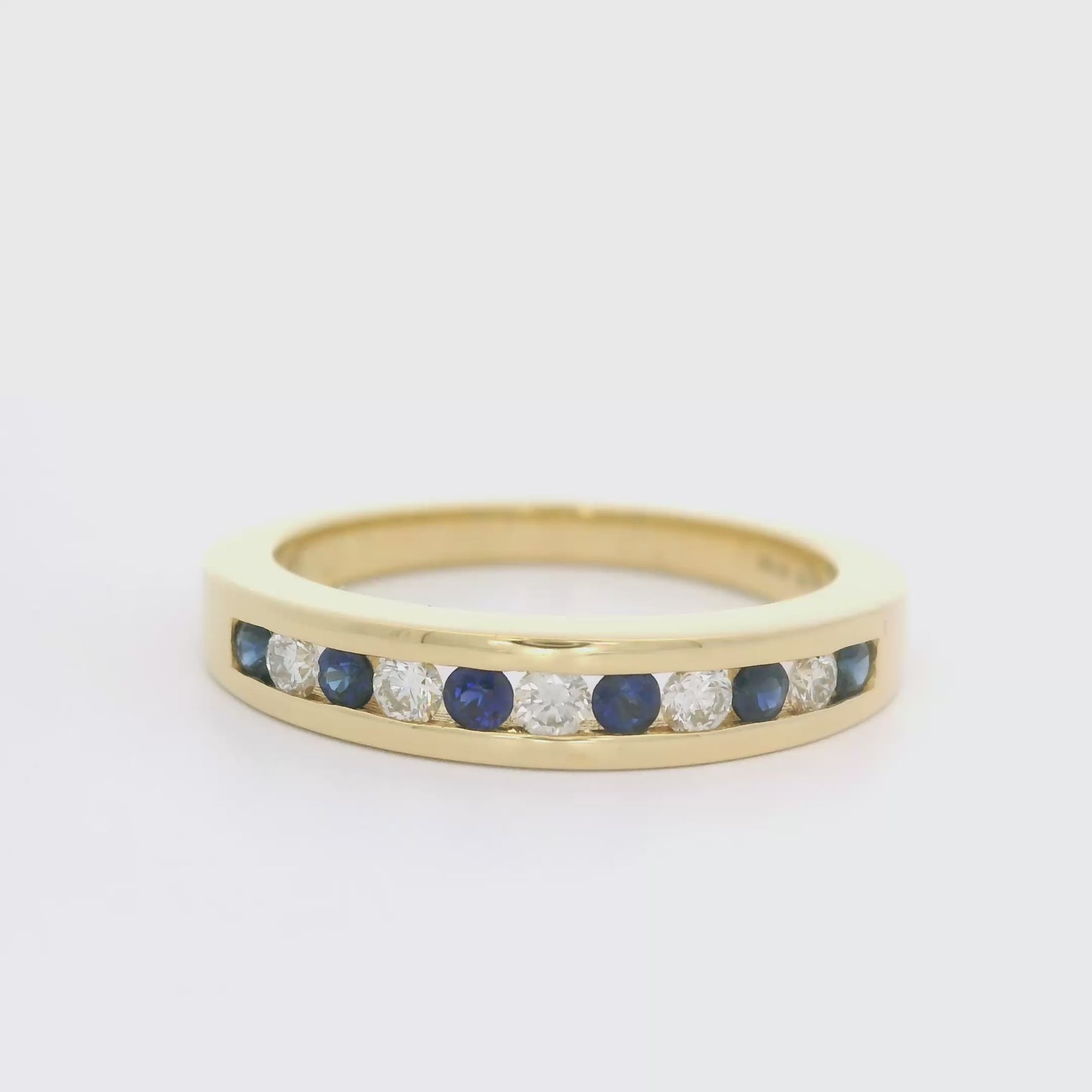 18 karaat geel gouden rijring van 4.27 gram en 2 tot 4 mm breed. Bezet met 6 saffieren met een totaalgewicht van 0.23 crt en 5 briljant geslepen diamanten met een totaalgewicht van 0.19 crt. Kleur: Top Wesselton Kwaliteit: VS1 Model: R 9952