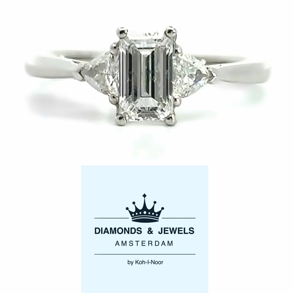 18 karaat wit gouden trilogiering van 2.7 gram. Bezet met 1 Baguette geslepen diamant van 0.97 crt Kleur: E Kwaliteit: SI en 2 Trilliant geslepen diamanten met een totaalgewicht van 0.32 crt Kleur: Top Wesselton Kwaliteit: VS2 Zdetting: 8 x 12 mm Model: R 10085