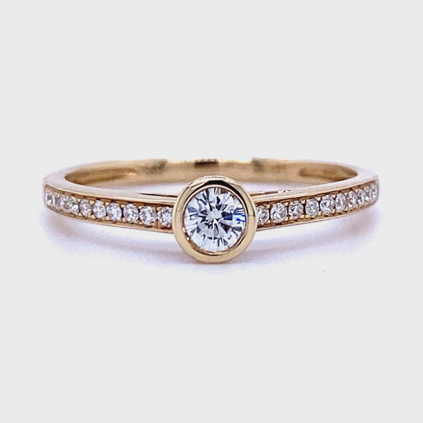 14 karaat geel gouden solitair pavé rij ring van 1.57 gram en 2 mm breed. Bezet met 1 briljant geslepen diamant in het midden van 0.15 crt en 22 briljant geslepen diamanten in de ringscheen met een totaalgewicht van 0.13 crt. Kleur: Top Wesselton Kwaliteit: VS Zetting: 5 mm Model: R 9603