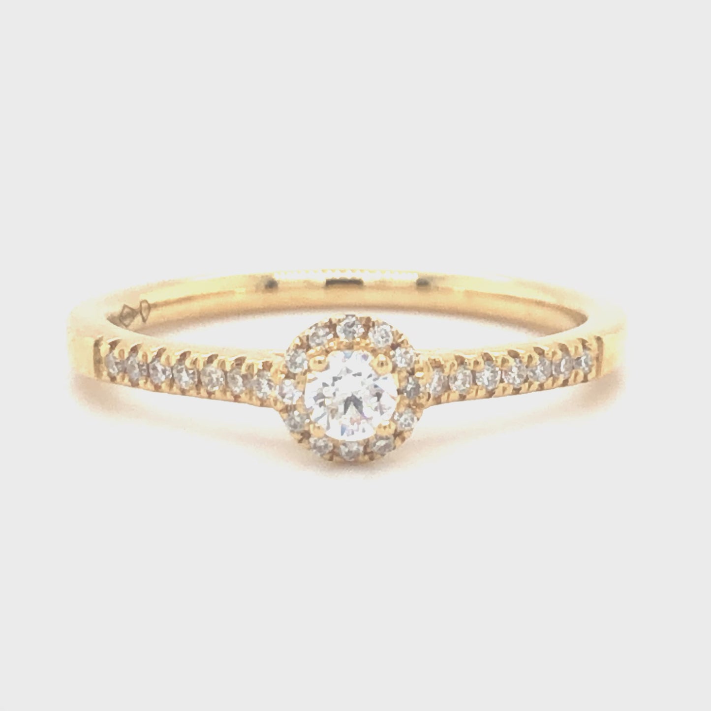 18 karaat geelgouden halo rij ring van 2.68 gram en 2 mm breed. Bezet met 1 briljant geslepen diamant van 0.21 crt en meerdere kleinere briljant geslepen diamanten met een totaalgewicht van 0.27 crt Kleur: Top Wesselton Kwaliteit: VS1 Zetting: 5 mm Model: R 9926