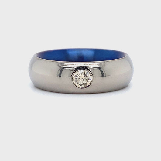 Brede titanium ring met blauwe binnenkant bezet met 1 briljant geslepen diamant van 0.24crt kleur top cape kwaliteit vs2 maat 17/53 7mm breed model r6284 €459