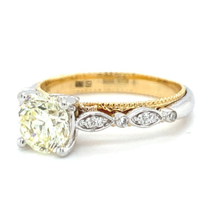 18 karaats wit met geel gouden fantasie ring van 4.15 gram en 3mm breed. Bezet met 1 briljant geslepen diamant van 1.12 crt kleur lichtgeel kwaliteit vs2 en 14 briljant geslepen diamanten met een totaalgewicht van 0.09 crt kleur G kwaliteit vs2 Model R8720