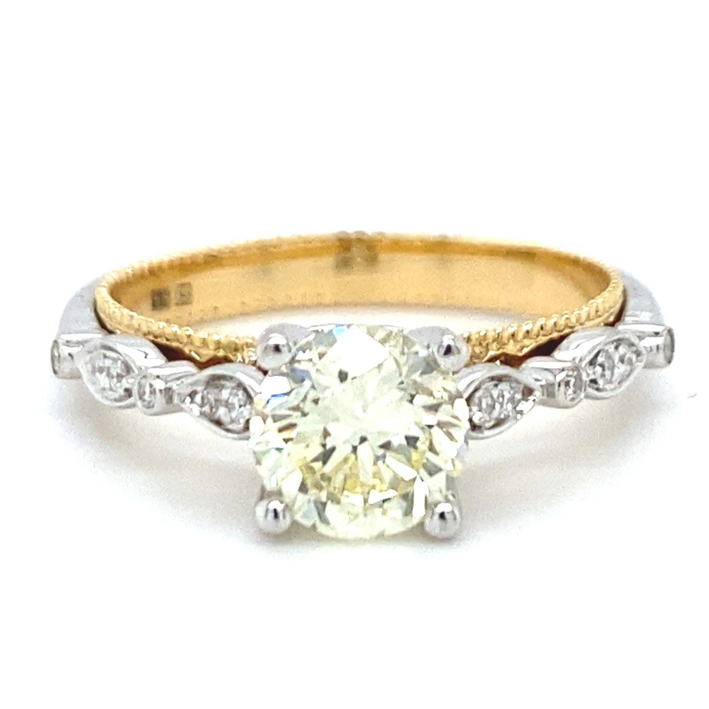 18 karaats wit met geel gouden fantasie ring van 4.15 gram e 3mm breed. Bezet met 1 briljant geslepen diamant van 1.12 crt kleur lichtgeel kwaliteit vs2 en 14 briljant geslepen diamanten met een totaalgewicht van 0.09 crt kleur G kwaliteit vs2 Model R8720