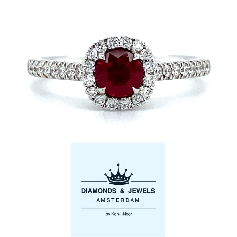 18 karaat witgouden rozet ring, bezet met 1 robijn van 0.51 crt die omringd is door kleinere briljant geslepen diamanten, die ook doorlopen in de ringband. De 32 diamanten hebben een totaalgewicht van 0.27 crt, kleur top wesselton kwaliteit vs model R 8946 