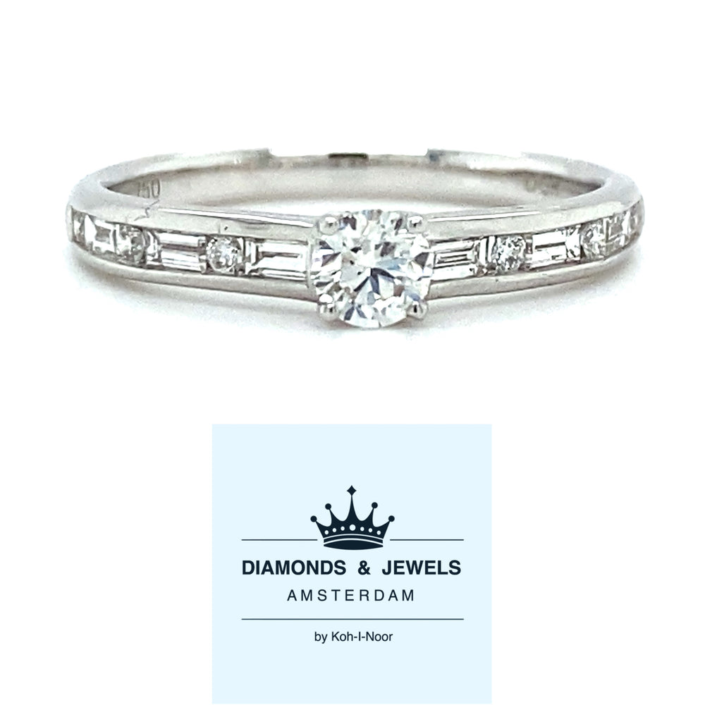18 karaats witgouden solitair pavéring van 2.3 gram. Bezet met 6 briljant geslepen diamanten met een totaalgewicht van 0.04 crt en 6 baguette geslepen diamanten met een totaalgewicht van 0.22 crt kleur Top Wesselton kwaliteit SI model R 9250