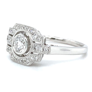 18 karaats witgouden Art Deco ring van 3.7 gram en 2 mm breed. Bezet met 1 briljant geslepen diamant van 0.17 crt en 27 briljant geslepen diamanten met een totaalgewicht van 0.27 crt Kleur: Top Wesselton Kwaliteit: VS Zetting: 10 x 16 mm Model R 9705