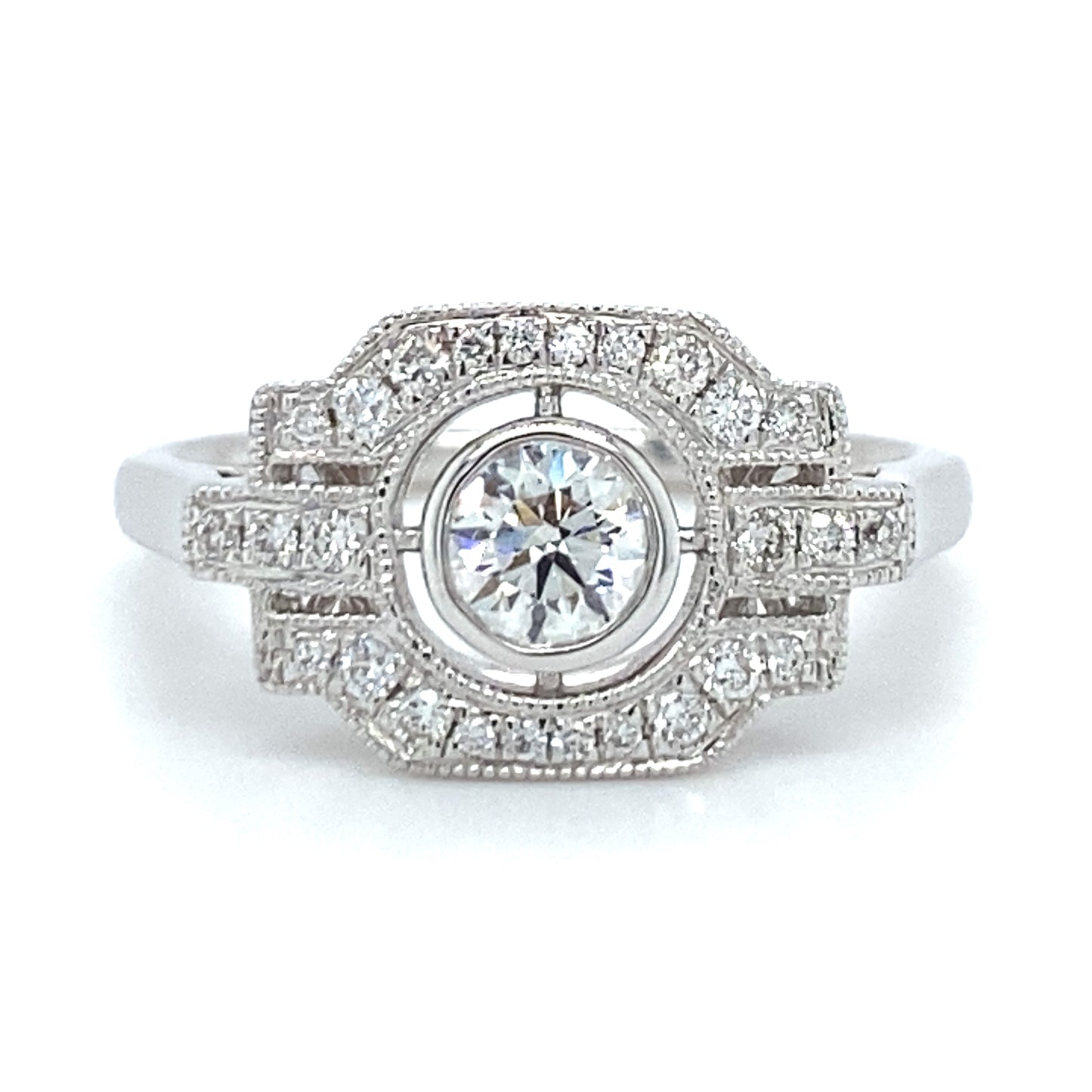 18 karaats witgouden Art Deco ring van 3.7 gram en 2 mm breed. Bezet met 1 briljant geslepen diamant van 0.17 crt en 27 briljant geslepen diamanten met een totaalgewicht van 0.27 crt Kleur: Top Wesselton Kwaliteit: VS Zetting: 10 x 16 mm Model R 9705