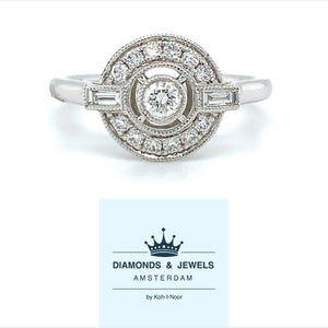 18 karaat Art Deco witgouden ring van 3.35 gram. Bezet met 13 briljant geslepen diamanten met een totaalgewicht van 0.26 crt en 2 baguette geslepen diamanten met een totaalgewicht van 0.10 crt Kleur: Top Wesselton Kwaliteit: VS Zetting: 11 x 13 mm Model R 9706