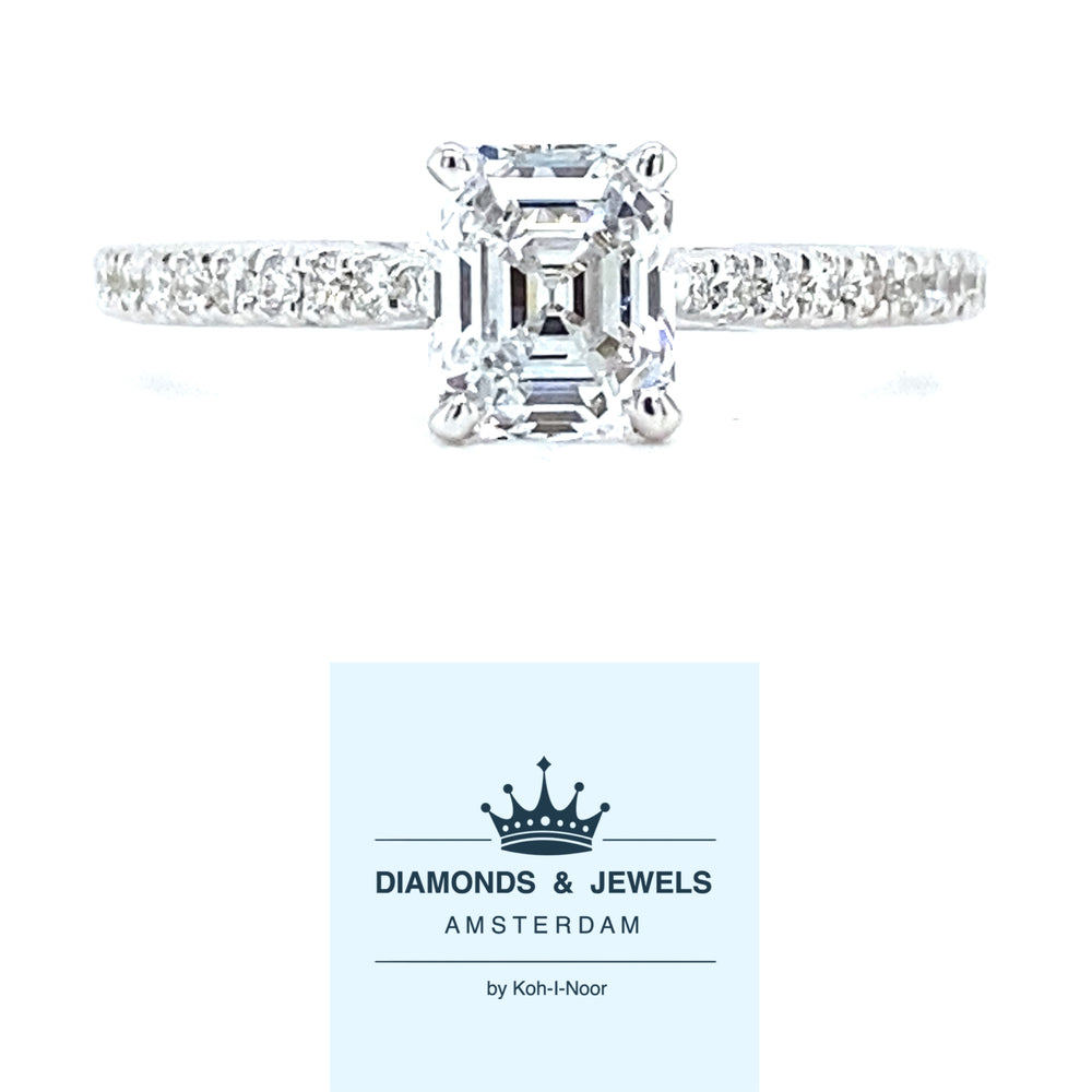 18 karaat witgouden ring van 1.95 gram en 2 mm breed. Bezet met 1 Asscher geslepen diamant van  0.67 crt kleur E kwaliteit VVS1 en 22 briljant geslepen diamanten met een totaalgewicht van 0.15 crt kleur top wesselton kwaliteit vs1 Zetting: 6 x 5 mm Model: R 9709