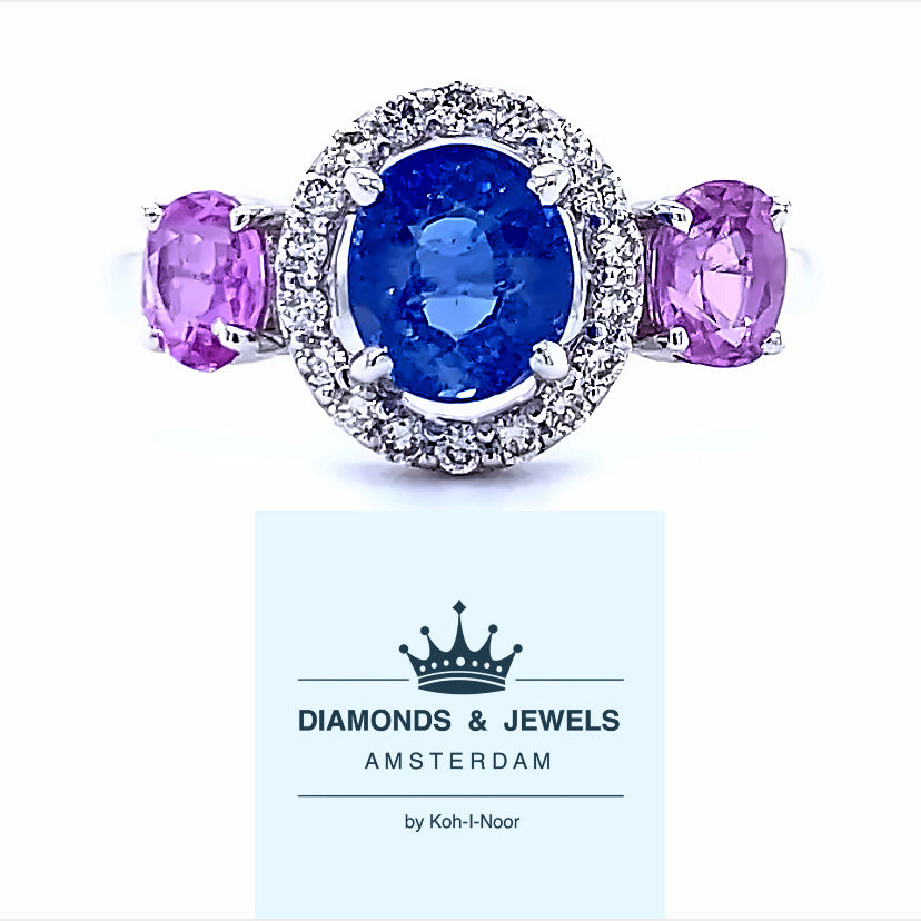 18 karaat wit gouden halo trilogie ring van 3.3 gram en 2 mm breed. Bezet met 18 briljant geslepen diamanten met een totaalgewicht van 0.20 crt. Kleur: Cape Kwaliteit: VS en 3 ovaal geslepen saffieren met een totaalgewicht van 2.26 crt Kleur: Blauw en Roze Zetting: 10 x 17 mm Model: R 9758ovaal geslepen saffier